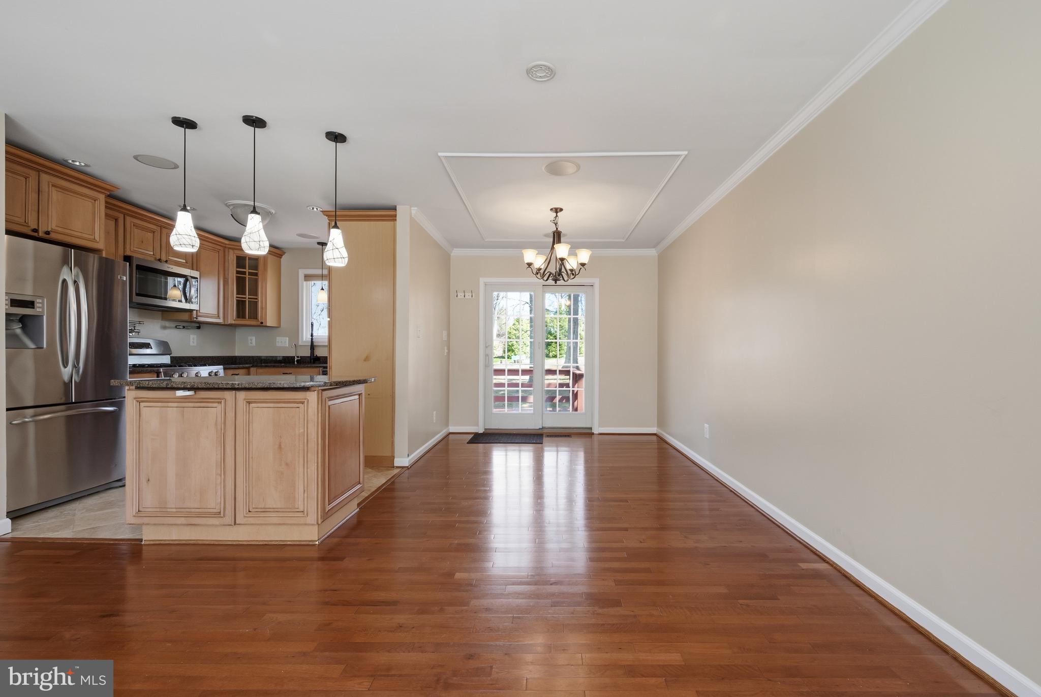 124 Woodland Road Gaithersburg, MD 20877 - Photo 11 of 79 a kitchen with granite countertop a refrigerator a sink dishwasher a stove and white cabinets with wooden floor