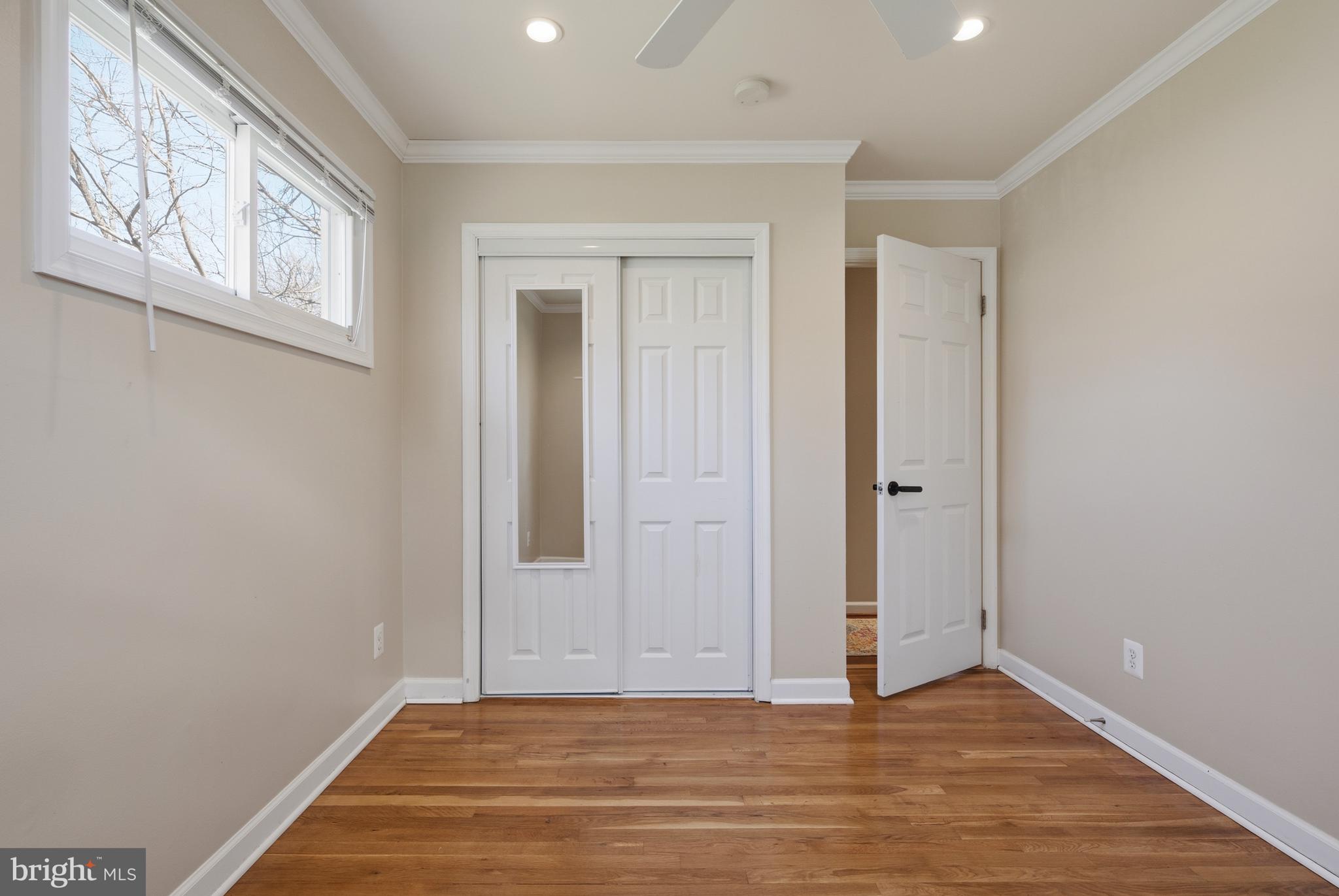 124 Woodland Road Gaithersburg, MD 20877 - Photo 24 of 79 a view of an empty room with wooden floor and a window