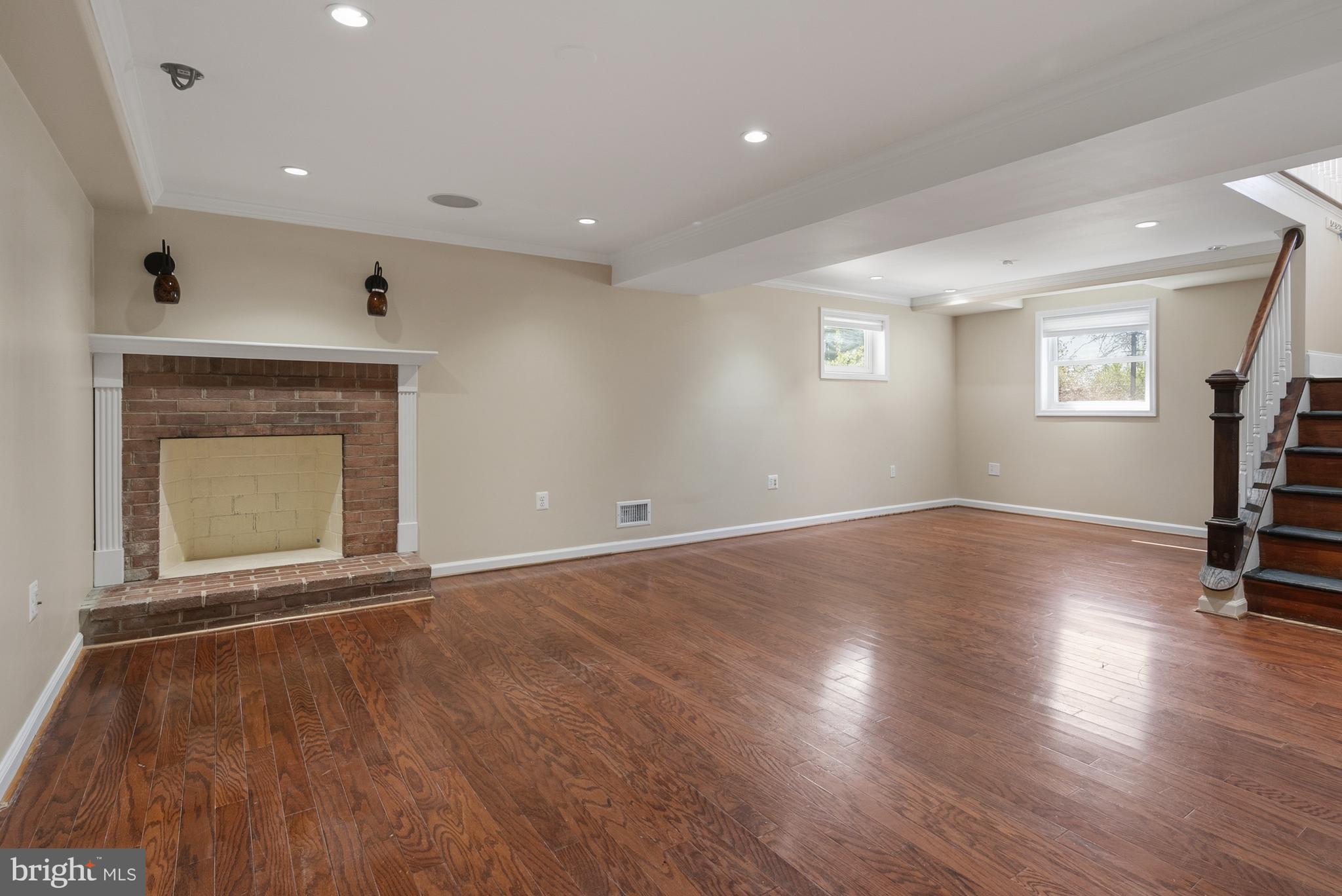 124 Woodland Road Gaithersburg, MD 20877 - Photo 29 of 79 an empty room with wooden floor fireplace and windows