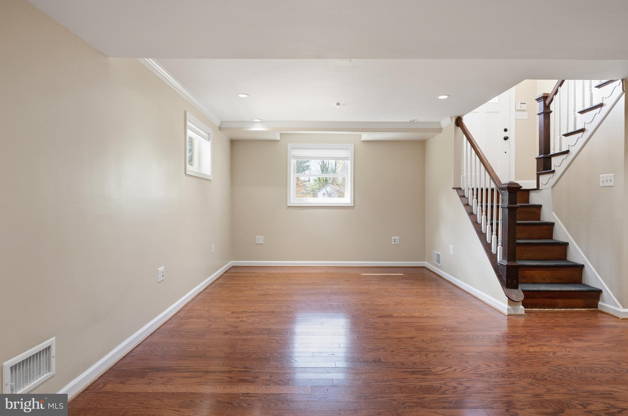 124 Woodland Road Gaithersburg, MD 20877 - Photo 30 of 79 wooden floor in an empty room with stairs and a window