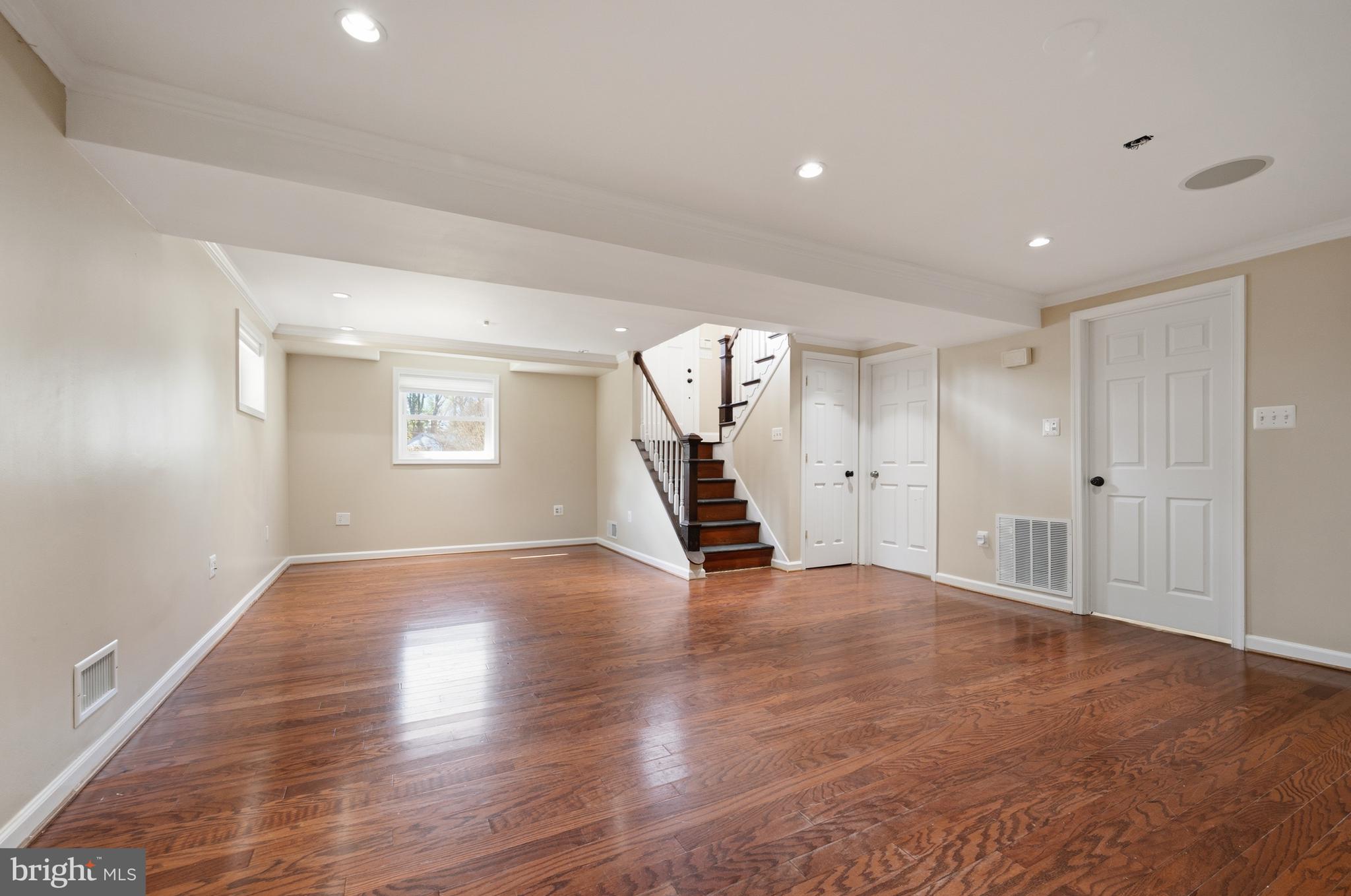 124 Woodland Road Gaithersburg, MD 20877 - Photo 35 of 79 a view of an empty room with wooden floor and stairs