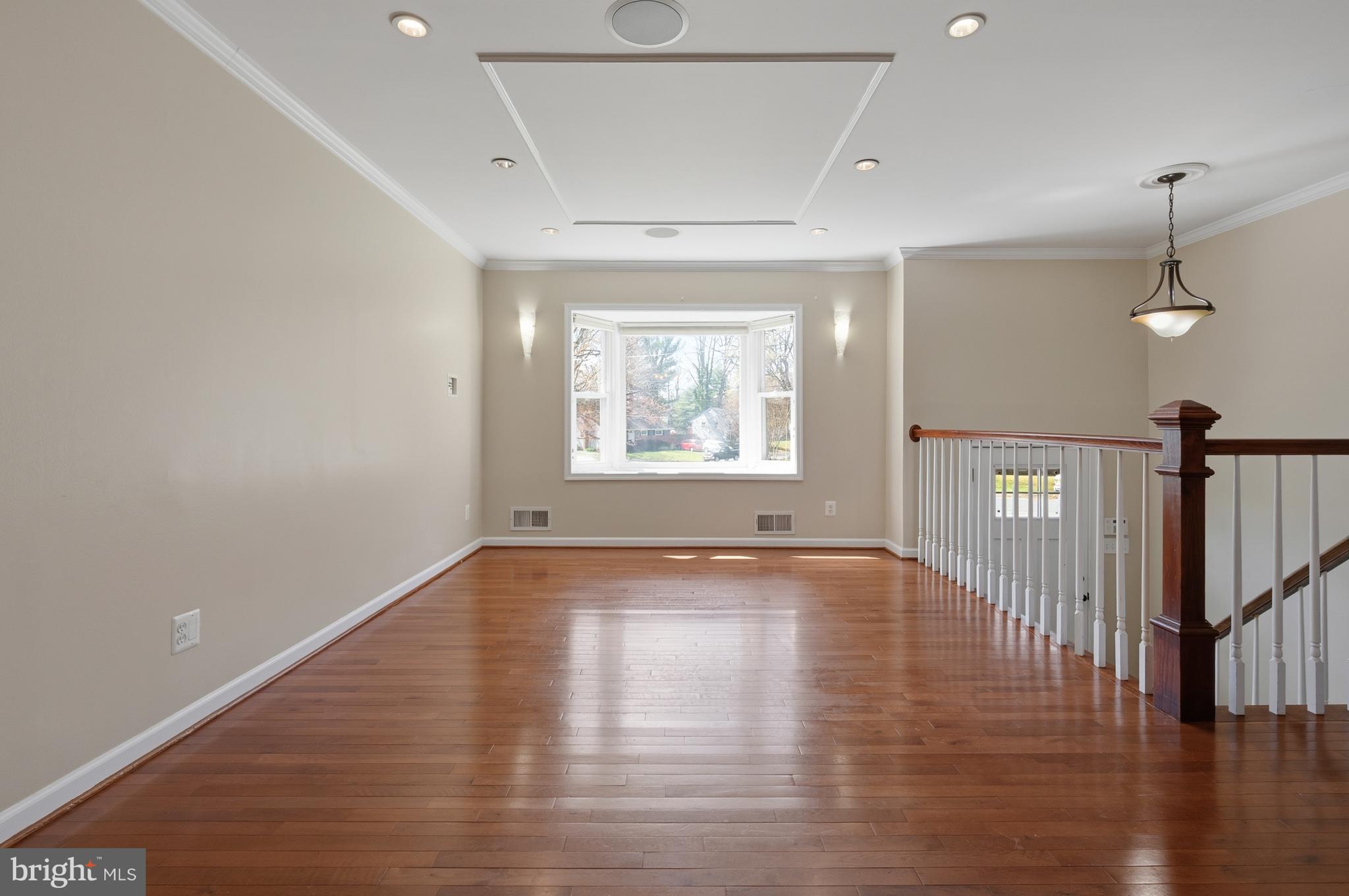 124 Woodland Road Gaithersburg, MD 20877 - Photo 6 of 79 a view of an empty room with wooden floor and a window
