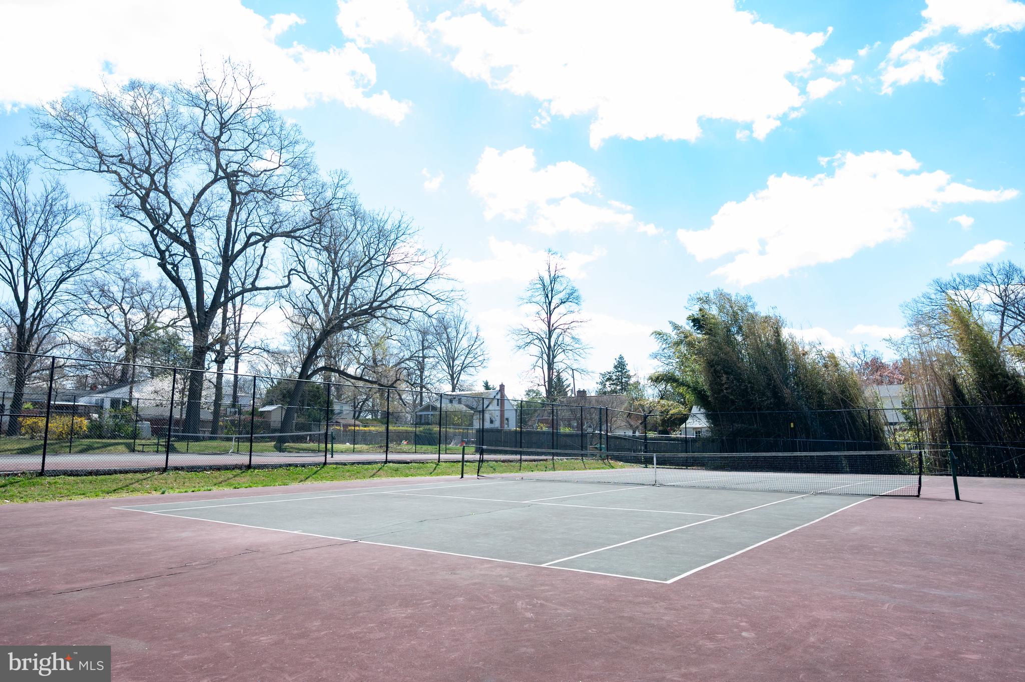 124 Woodland Road Gaithersburg, MD 20877 - Photo 75 of 79 a view of a tennis ground with large trees