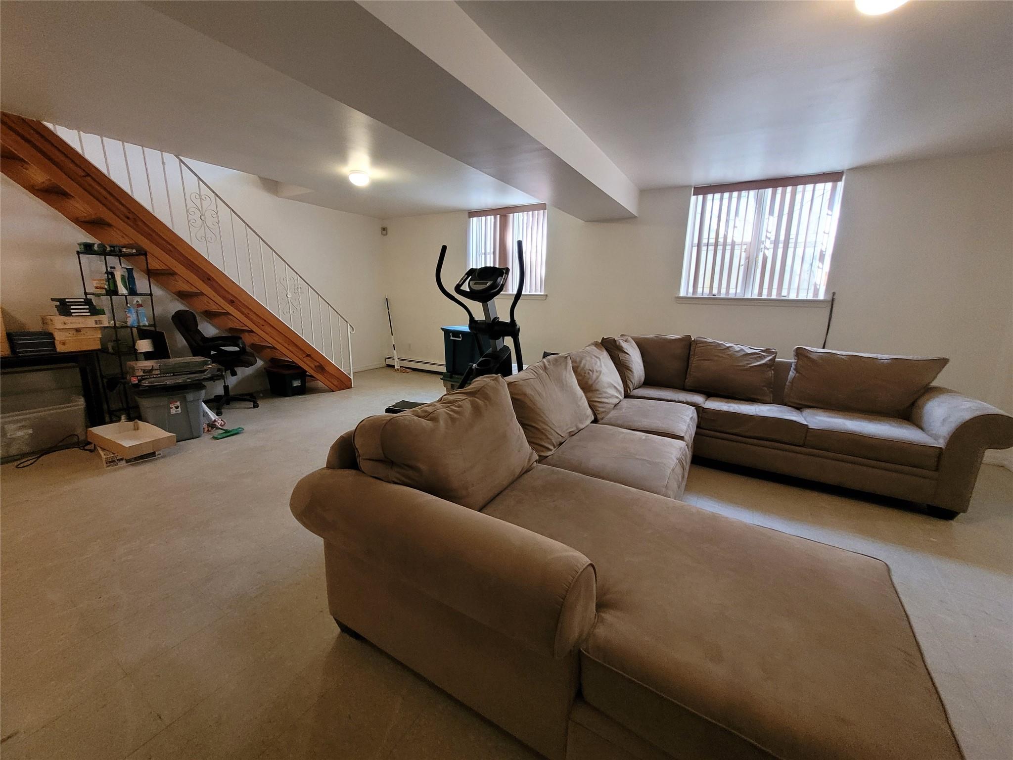 1124 67th Street, Unit A3 Brooklyn, NY 11219 - Photo 14 of 20 Living area with carpet, a baseboard heating unit, and stairway
