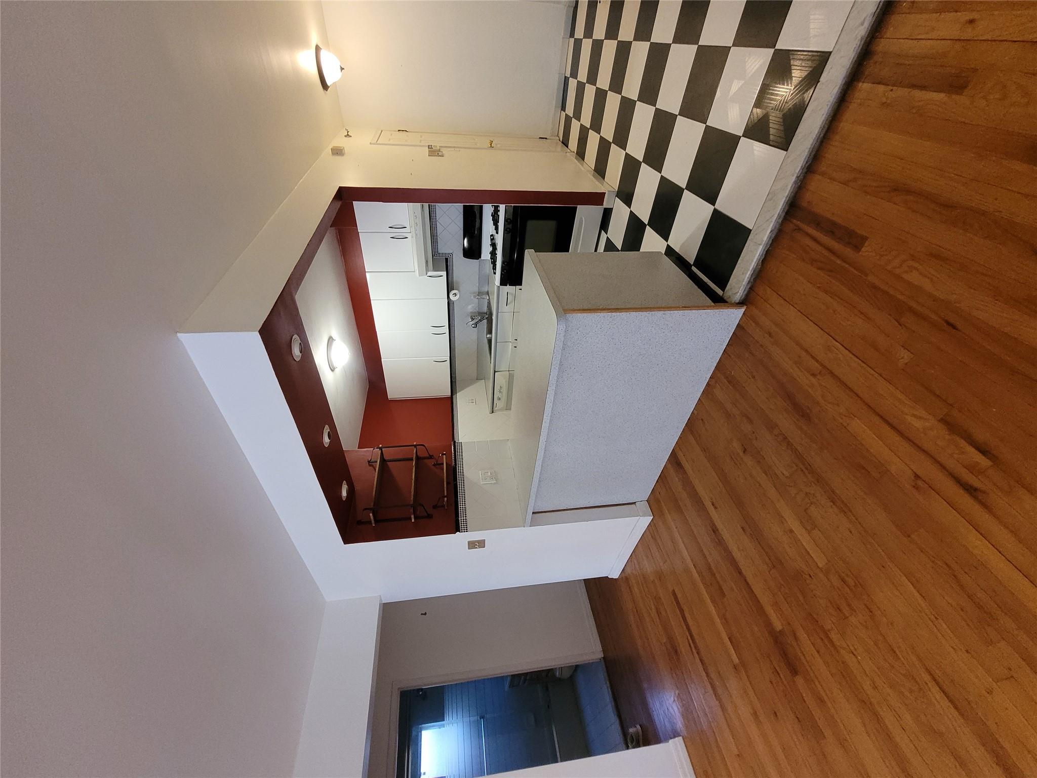 1124 67th Street, Unit A3 Brooklyn, NY 11219 - Photo 4 of 20 Kitchen featuring light countertops, ventilation hood, white cabinetry, a peninsula, and range