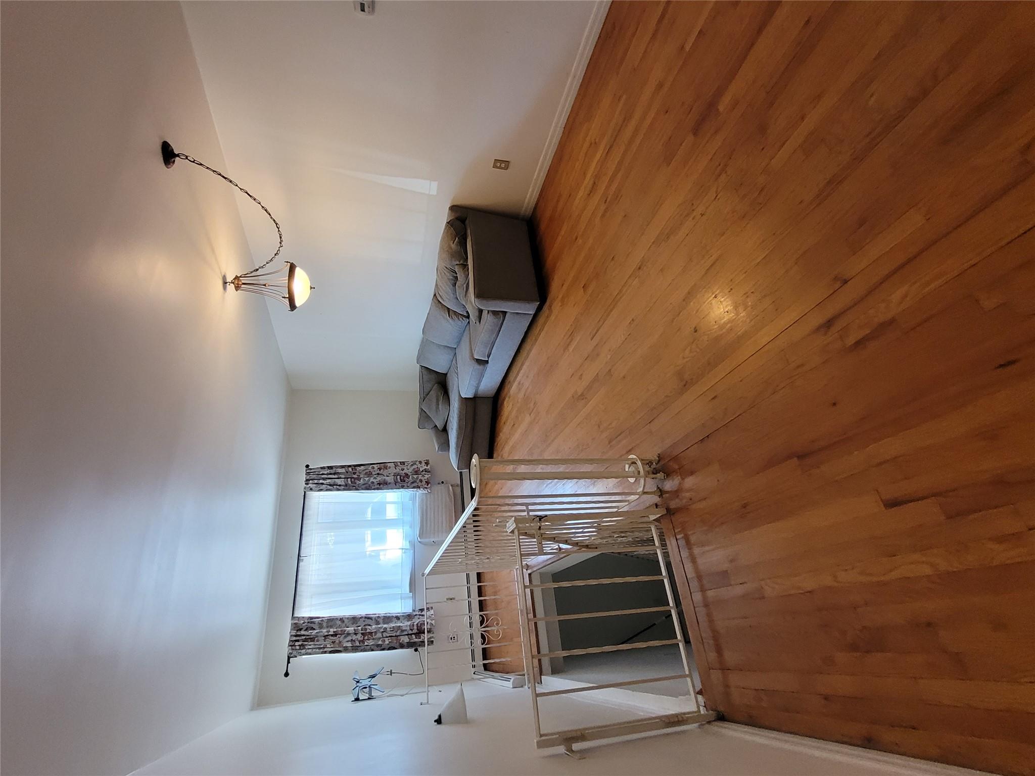 1124 67th Street, Unit A3 Brooklyn, NY 11219 - Photo 6 of 20 Unfurnished living room with hardwood / wood-style floors and baseboards