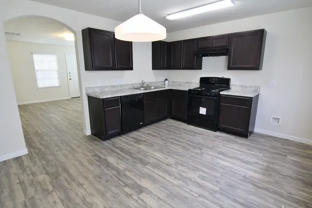a kitchen with a stove refrigerator and a sink