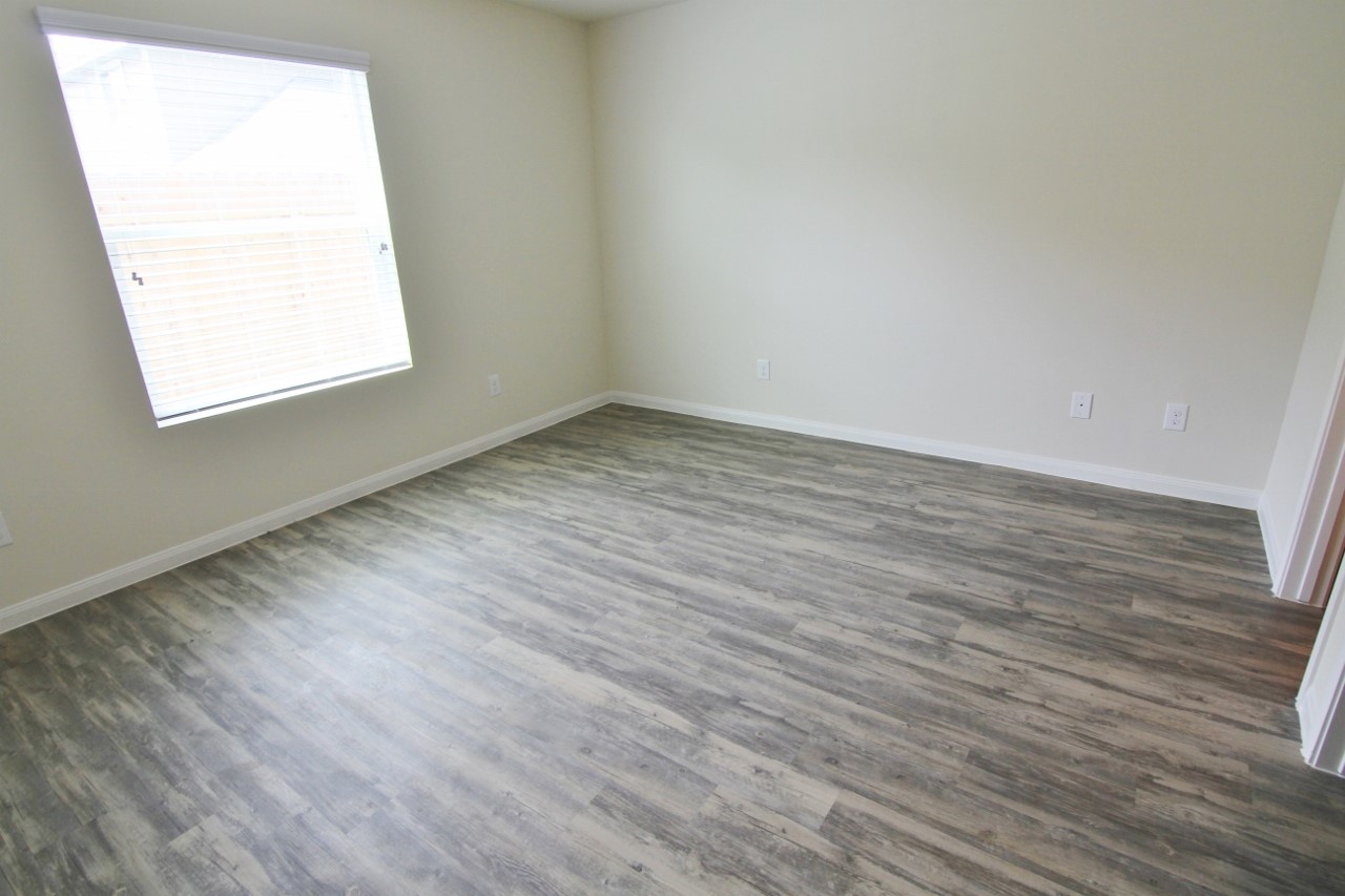 5486 Quail Cove Lane Houston, TX 77053 - Photo 3 of 7 an empty room with wooden floor and windows