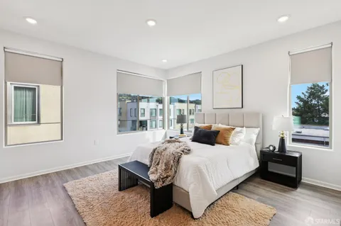 a bedroom with a bed wooden floor and window