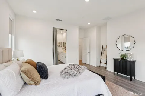 a bedroom with a bed a mirror and a chandelier