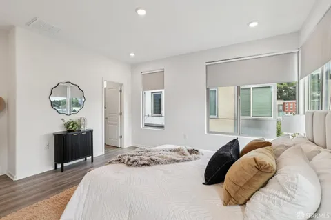 a bedroom with a bed mirror and a large window