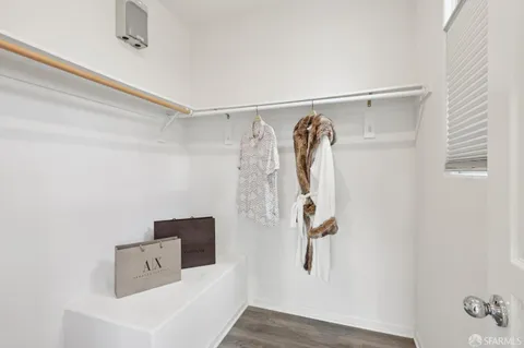 a view of walk in closet with clothes and shoes