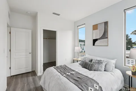 a bedroom with a large bed and a painting on the wall