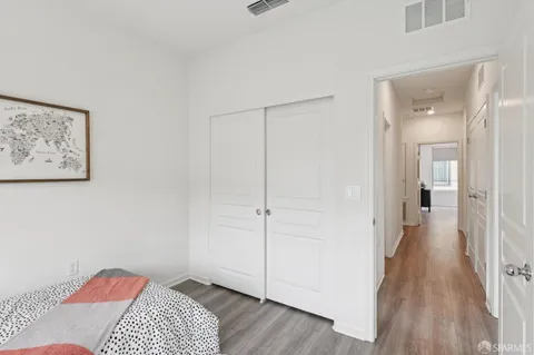 a view of a bedroom with wooden floor