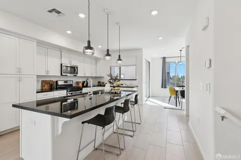 a kitchen with stainless steel appliances kitchen island granite countertop a sink and a refrigerator
