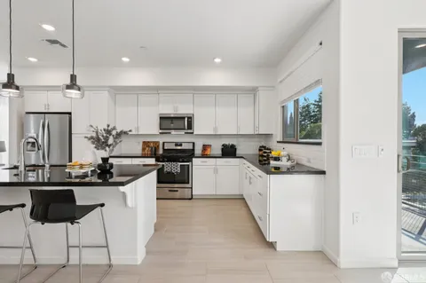 a kitchen with cabinets and chairs