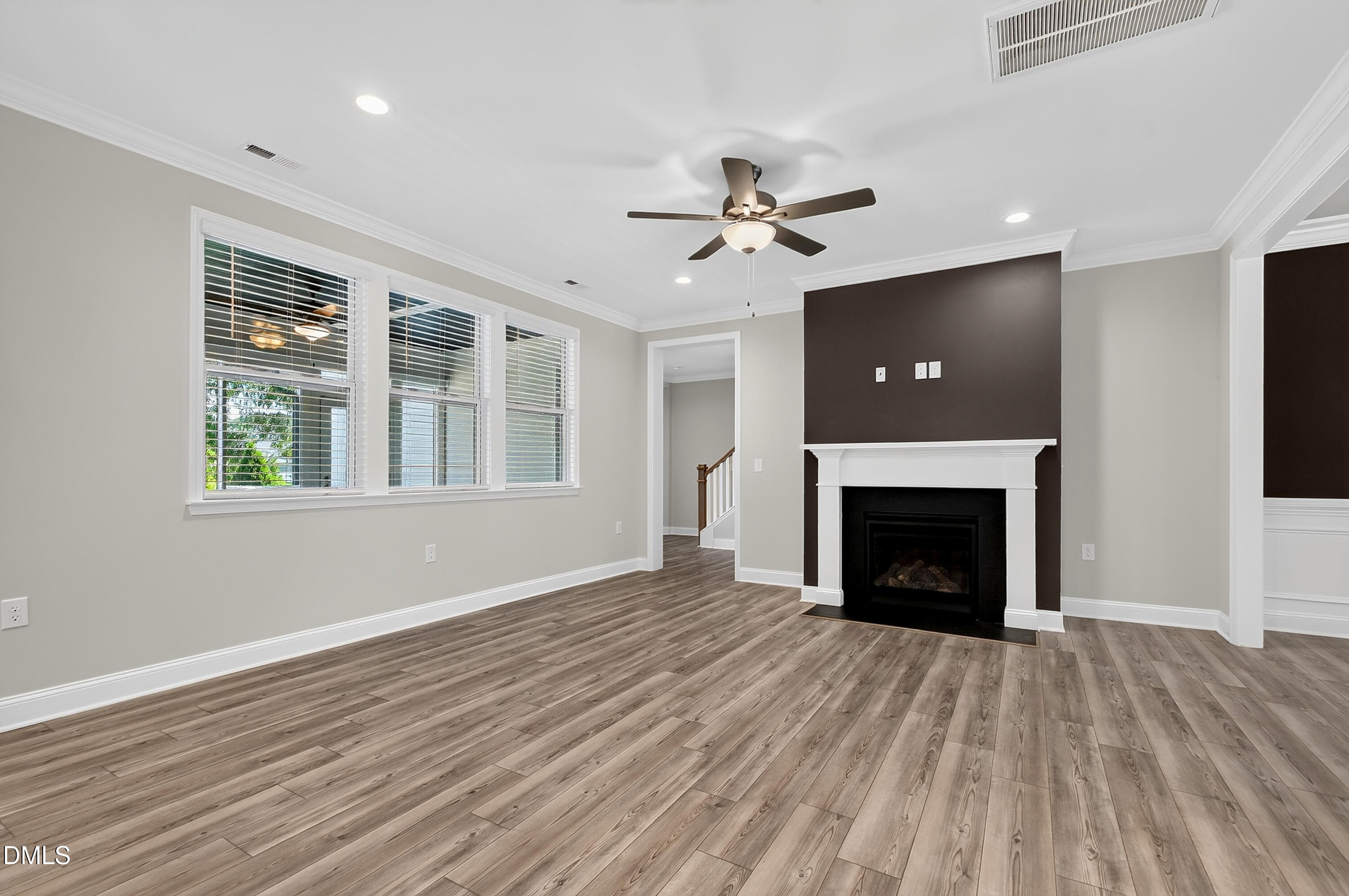1300 Commons Ford Place Apex, NC 27539 - Photo 10 of 70 a view of an empty room with wooden floor fireplace and a window
