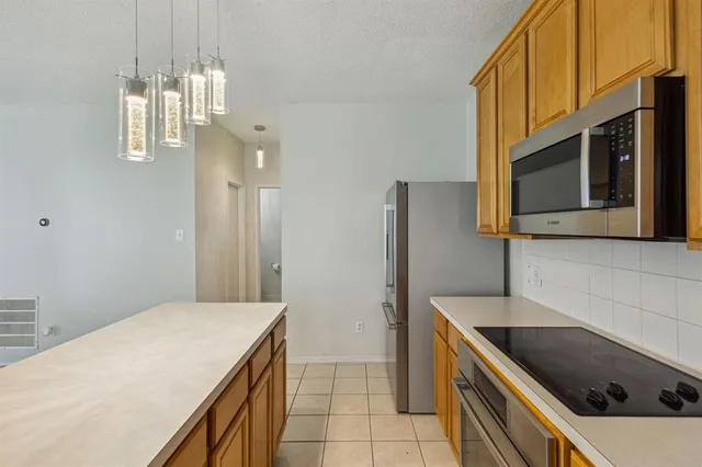 a kitchen with stainless steel appliances granite countertop a sink and a stove top oven with wooden floor