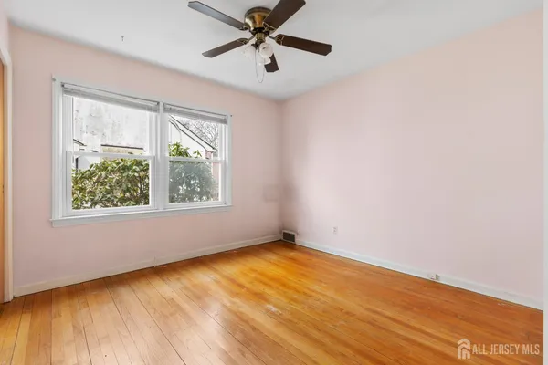 an empty room with a window and a ceiling fan