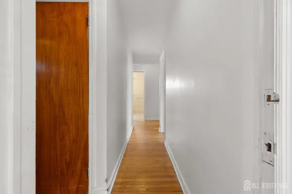a view of a hallway with wooden floor