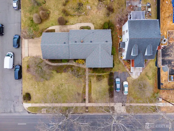 an aerial view of residential houses with outdoor space and parking