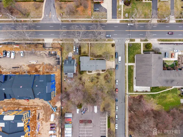 a front view of a house with a yard covered with snow and trees