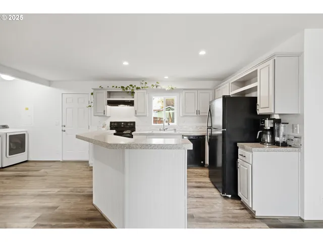 a kitchen with a refrigerator and a stove top oven