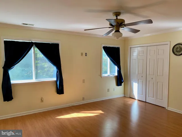 a view of a livingroom with wooden floor and a ceiling fan