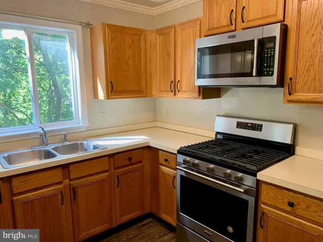 a kitchen with stainless steel appliances granite countertop a sink stove and microwave
