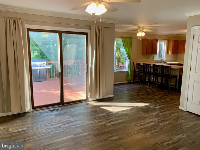 a view of a room with wooden floor fireplace and windows