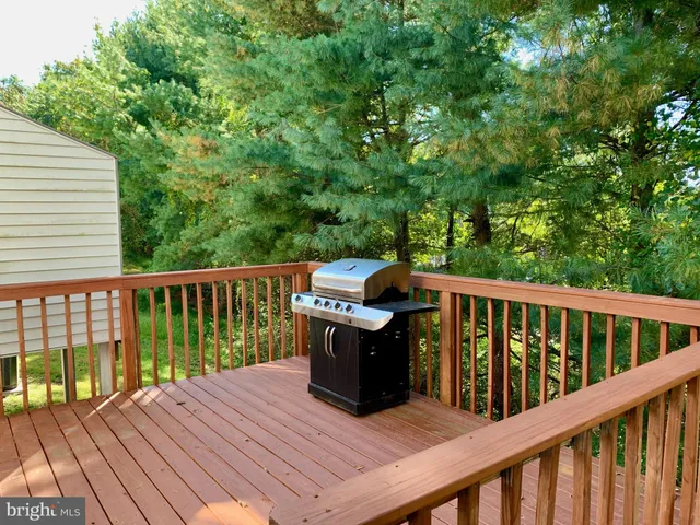 a view of roof deck with furniture and trees around