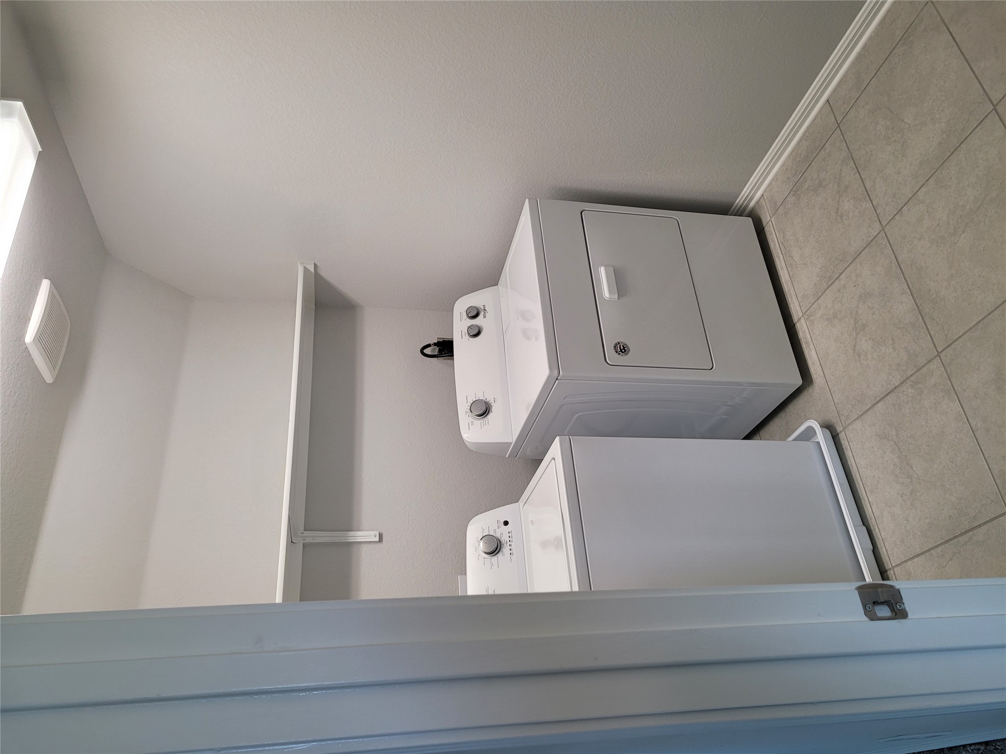 131 Wild Wind Cove Jarrell, TX 76537 - Photo 23 of 26 Dedicated laundry area featuring tile flooring, white walls, and an overhead shelf