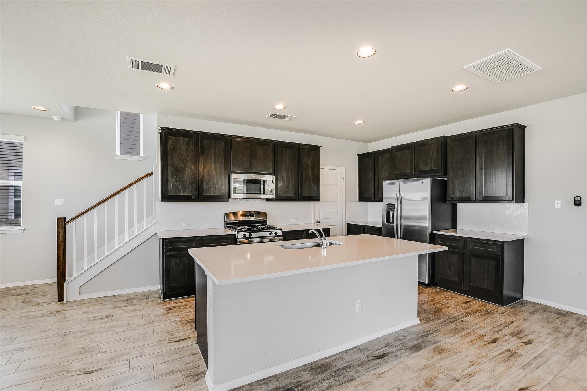 204 Crescent Street Georgetown, TX 78626 - Photo 2 of 12 a kitchen with stainless steel appliances a sink a stove a refrigerator cabinets and wooden floor
