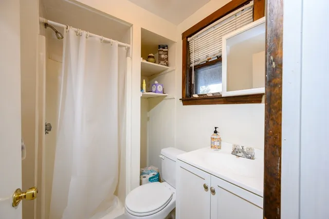 a bathroom with a sink vanity mirror and toilet