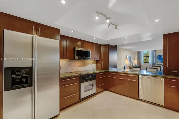 a kitchen with stainless steel appliances granite countertop a refrigerator and a sink