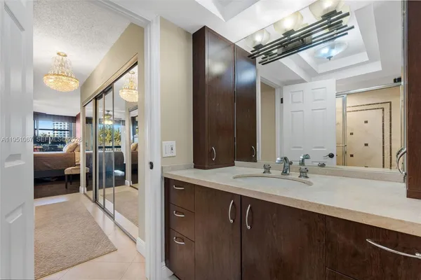 a en suite bathroom with a sink a large mirror and shower