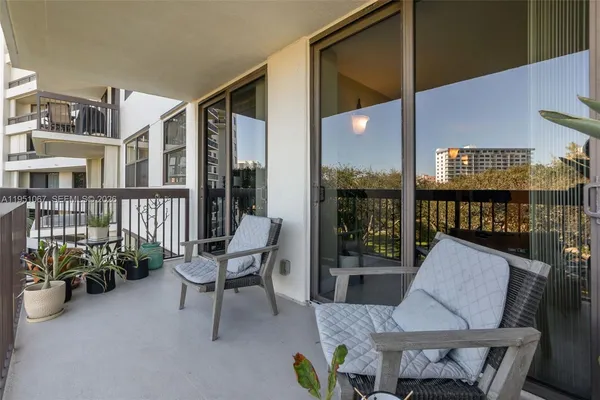 a balcony view with couple of chairs and a potted plant