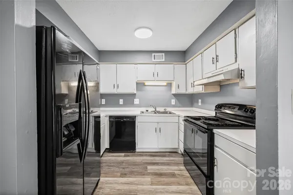 a kitchen with granite countertop cabinets stainless steel appliances and wooden floor