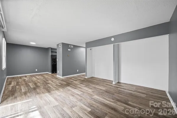 a view of empty room with wooden floor