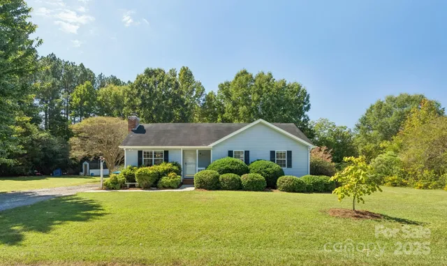 a front view of a house with a yard and trees