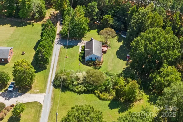 a aerial view of a house with a yard swimming pool and outdoor seating