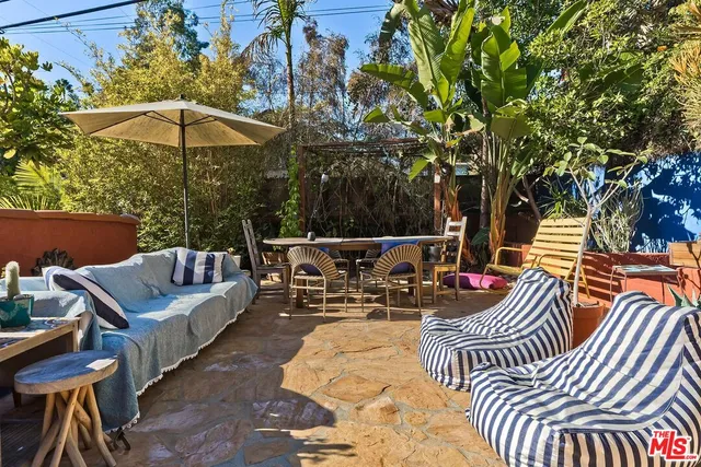a view of a house with a yard and potted plants