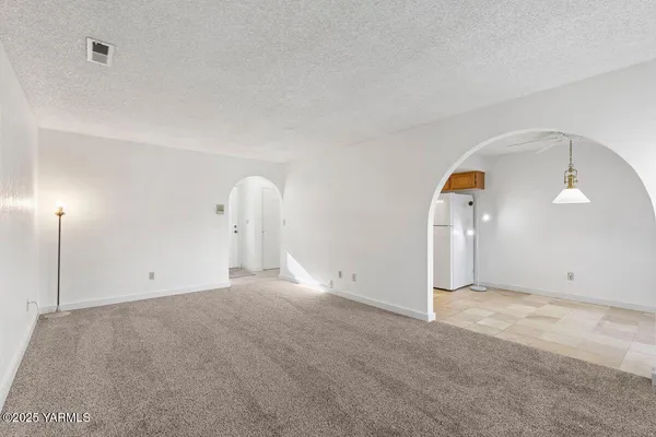 an empty room with a bathroom and a mirror
