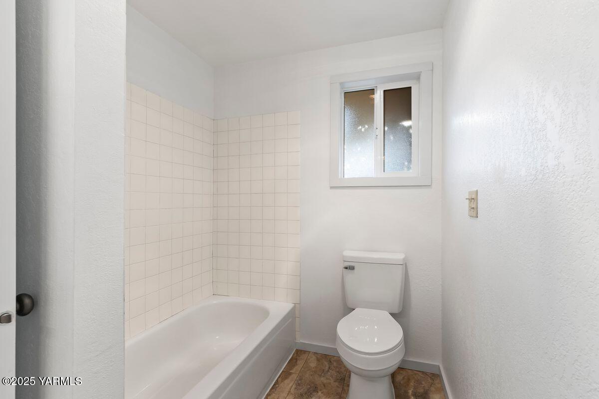 207 South 8th Avenue, Unit 7 Yakima, WA 98902 - Photo 17 of 32 a white toilet sitting next to a bath tub