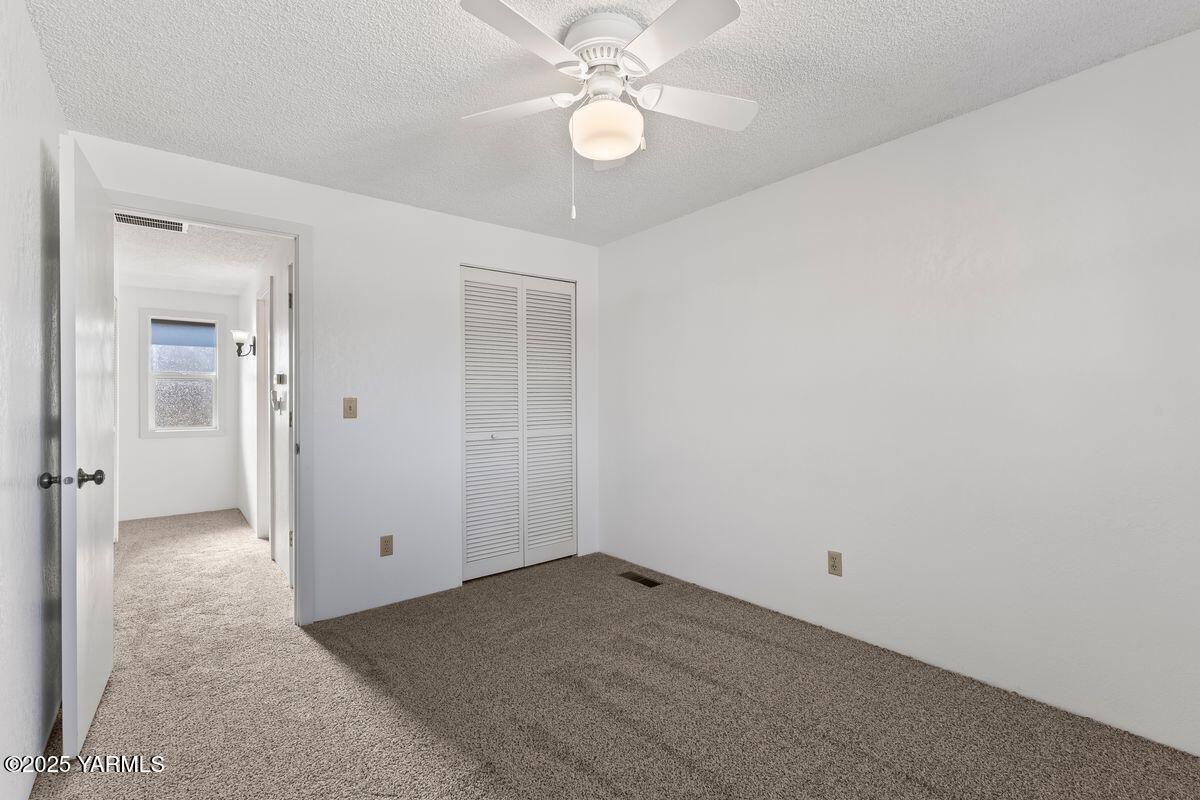 207 South 8th Avenue, Unit 7 Yakima, WA 98902 - Photo 19 of 32 an empty room with chandelier fan and closet area