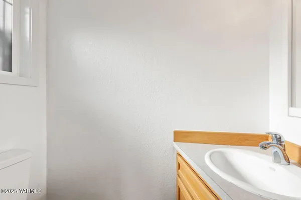 an empty room with a chandelier fan and windows