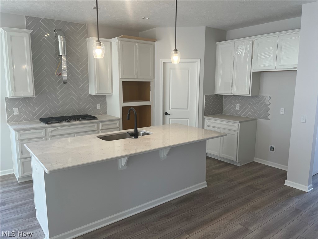 745 River Run Road Aurora, OH 44202 - Photo 2 of 7 Kitchen featuring hanging light fixtures, a center island with sink, and white cabinetry