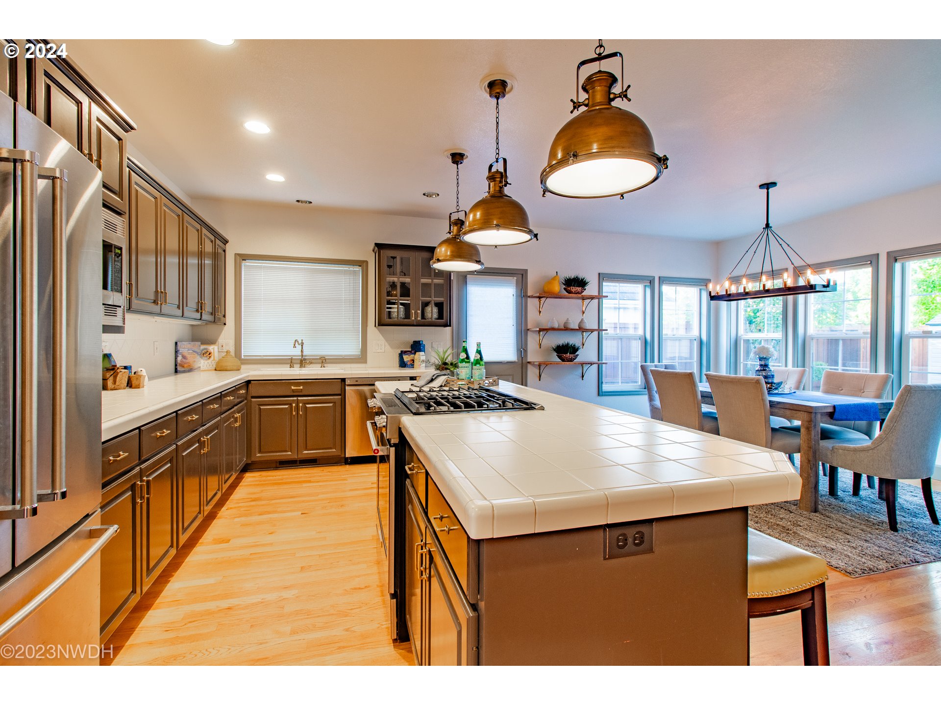 3435 Hampton Way Eugene, OR 97401 - Photo 16 of 46 a kitchen with a stove a refrigerator and a dining table with wooden floor