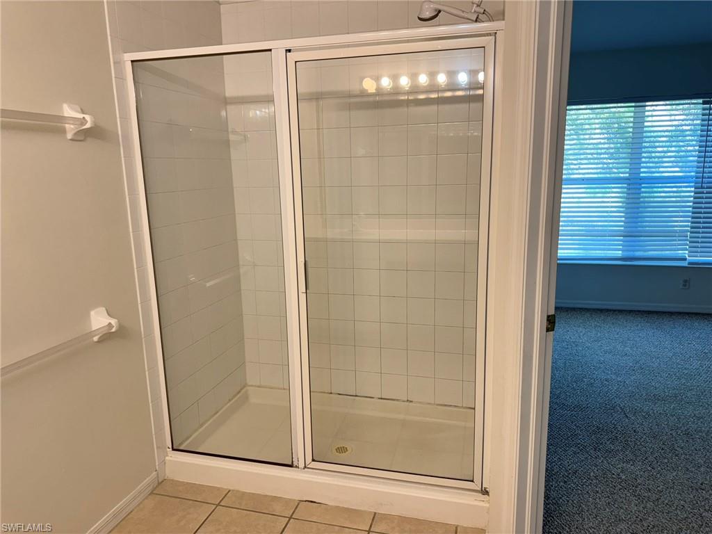 860 Hampton Circle, Unit 165 Naples, FL 34105 - Photo 15 of 38 a bathroom with a glass shower door