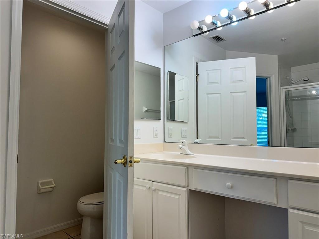 860 Hampton Circle, Unit 165 Naples, FL 34105 - Photo 16 of 38 a bathroom with a sink and mirror with toilet